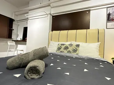 a bedroom with a large bed with a large headboard at CEOZ1 Duplex 1BR Suite #Disneys HS #USM #SPICE in Bayan Lepas