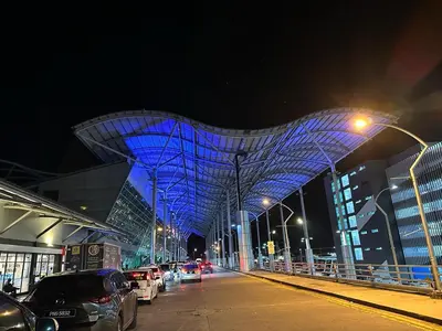 a blue building with cars parked on a street at night at CEOZ1 Duplex 1BR Suite #Disneys HS #USM #SPICE in Bayan Lepas