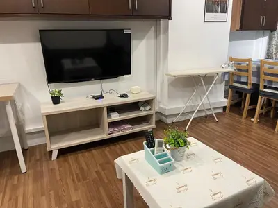 a living room with a flat screen tv on a entertainment center at CEOZ1 Duplex 1BR Suite #Disneys HS #USM #SPICE in Bayan Lepas