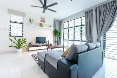 a living room with a couch and a tv at Solok Sungai Emas By Plush in Batu Ferringhi
