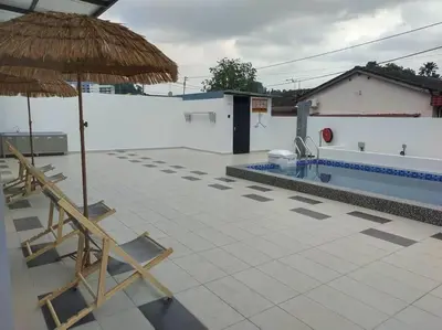 a patio with two umbrellas and a swimming pool at Morning de Ville-Private Pool BBQ Karaoke 26-30pax in Ipoh