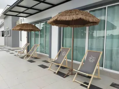 a row of chairs and umbrellas on a patio at Morning de Ville-Private Pool BBQ Karaoke 26-30pax in Ipoh