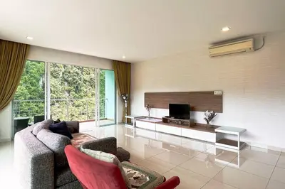 a living room with a couch and a tv at Ipoh Tambun Private Unit Lakeside Residences in Kampong Batu Lapan