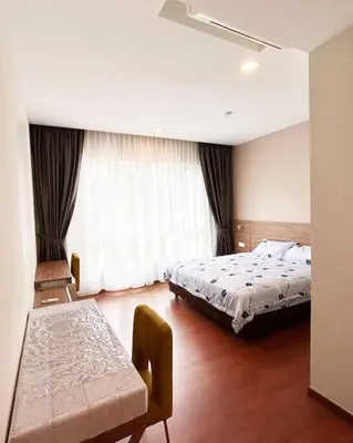 a bedroom with a bed and a table in it at Ipoh Tambun Private Unit Lakeside Residences in Kampong Batu Lapan