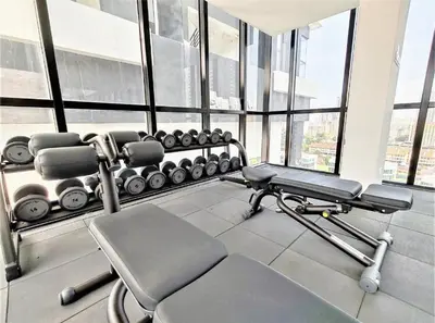 a gym with a bench and weights in a room with windows at Infinity Pool, Georgetown, Up to 11 Pax, 3 Bedrooms, 2 Bathrooms, 2 Car Parks by Star Home in Jelutong