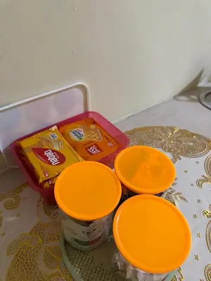 a table with three orange plates and some food at DHW Homestay in Simpang Ampat Semanggol