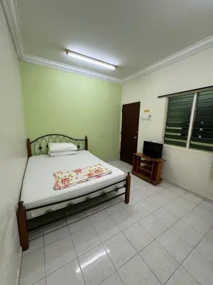 a bedroom with a bed and a television in it at Happy Homestay in Ipoh