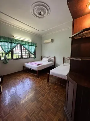 a room with two beds and a tv in it at Happy Homestay in Ipoh