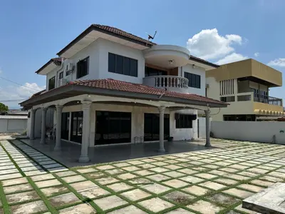 a large white house with a courtyard in front of it at Happy Homestay in Ipoh