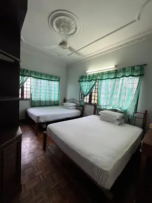 two beds in a room with two windows at Happy Homestay in Ipoh