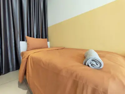 a bed with an orange comforter in a bedroom at Urban Simplicity Suite, 5 Pax, 2 Car Parks at Urban Suites Georgetown by SuperStay in Jelutong