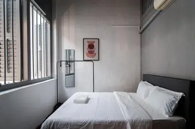 a bedroom with a white bed with a window at Aayu Melayu - George Town Penang in George Town