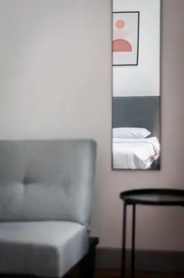 a living room with a chair and a mirror at Aayu Melayu - George Town Penang in George Town