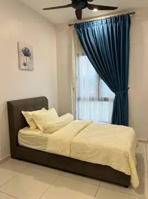 a bed in a bedroom with a blue curtain at Cozy Urban Retreat @ Horizon in Ipoh