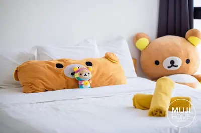 two stuffed teddy bears sitting on a bed at MUJI X Rilakkuma Seaview 3BR Georgetown with TV Box in Jelutong