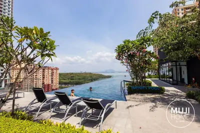 a view of a river with chairs and people in the water at MUJI X Rilakkuma Seaview 3BR Georgetown with TV Box in Jelutong