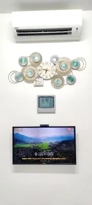 a clock and a tv on a wall at Putra 2 Homestay in Gua Musang