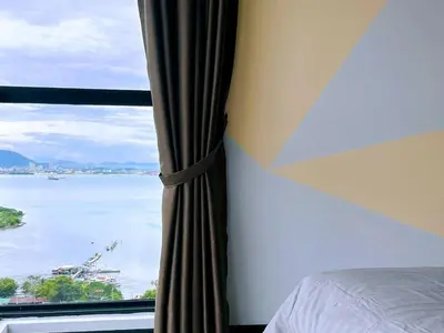 a bedroom with a window with a view of the water at ASC Smart Urban Suite Jelutong 2BR 3BR in Jelutong