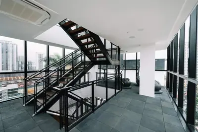 a spiral staircase in a room with windows at ASC Smart Urban Suite Jelutong 2BR 3BR in Jelutong