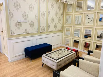 a living room with a couch and a blue ottoman at zam homestay kulim perdana hitech utk Msliim shj in Kulim
