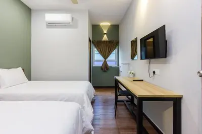a room with two beds and a desk and a tv at Newly 5BR Cottage House Retreats (Free Parking) in Butterworth