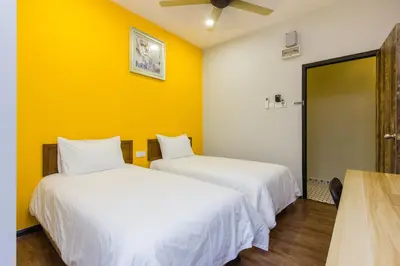 two beds in a room with yellow walls at Newly 5BR Cottage House Retreats (Free Parking) in Butterworth