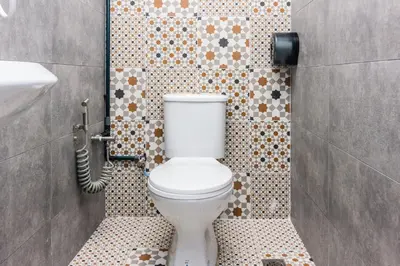 a bathroom with a toilet and a tiled wall at Newly 5BR Cottage House Retreats (Free Parking) in Butterworth
