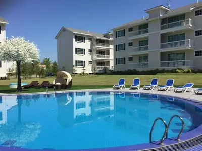 a large swimming pool with chairs and a building at The Trails Kampar in Kampong Malim Nawar