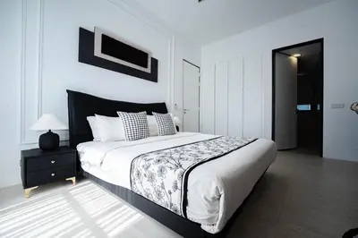 a bedroom with a bed with a black and white comforter at Batu Ferringhi By The Sea Luxurious 2BR Suite 6 Pax in Batu Ferringhi