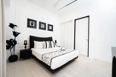 a white bedroom with a large bed and a window at Batu Ferringhi By The Sea Luxurious 2BR Suite 6 Pax in Batu Ferringhi