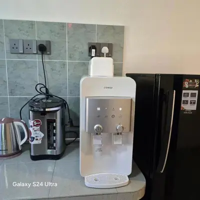 a coffee maker sitting on a counter next to a refrigerator at 82,Dream Guest House in Tanjung Piandang