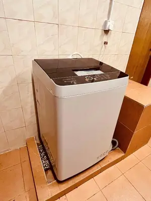 a washing machine sitting on the floor in a bathroom at Nature Surrounded Riverside Villa with BBQ ,& SWIMMING POOL in George Town