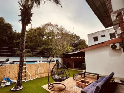 a patio with a hammock and a palm tree at Nature Surrounded Riverside Villa with BBQ ,& SWIMMING POOL in George Town