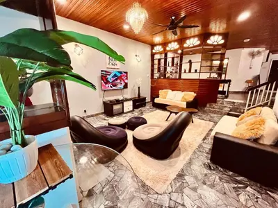 a living room with leather furniture and a potted plant at Nature Surrounded Riverside Villa with BBQ ,& SWIMMING POOL in George Town