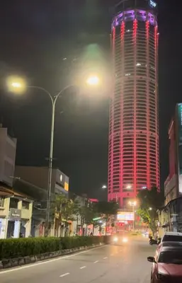 a tall building with red and purple lights on it at GG 98 Hotel in George Town
