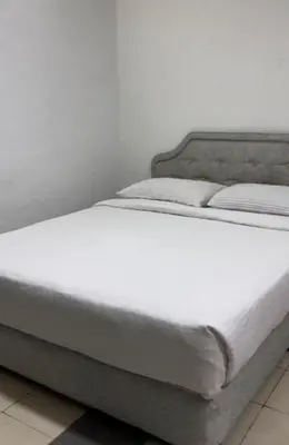 a bed with white sheets and pillows on it at GG 98 Hotel in George Town