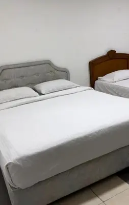 two beds with white sheets and pillows in a bedroom at GG 98 Hotel in George Town