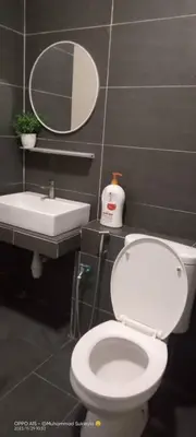 a bathroom with a toilet and a sink and a mirror at RJ Studio 1 - Kompleks Mutiara in Gua Musang