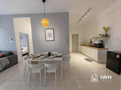 a living room and kitchen with a table and chairs at Ipoh Horizon Skypool Town Suites 4-11pax by IWH Suites in Ipoh