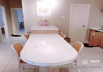 a white table and chairs in a room with a kitchen at Ipoh Horizon Skypool Town Suites 4-11pax by IWH Suites in Ipoh