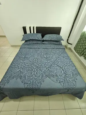 a bed with a blue comforter and pillows at Seberang Jaya Family Pool Homestay Near Hospital 3 Bedroom Aircond 2 Bathroom & Family Room Aircond in Permatang Janggus