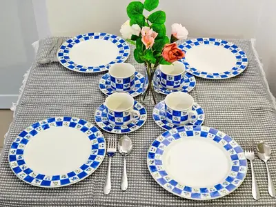 a table with blue and white plates and a vase with flowers at Tropicana 218 Macalister by NGN in George Town