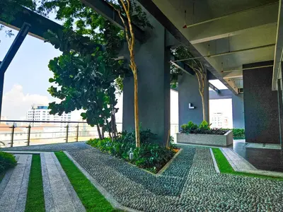 a building with a courtyard with trees and grass at Tropicana 218 Macalister by NGN in George Town