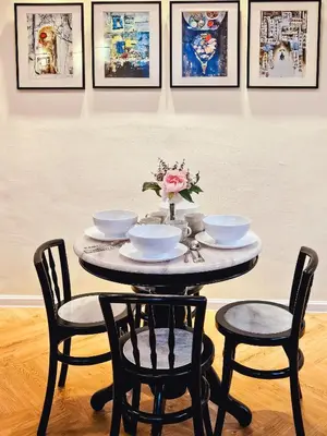 a table with chairs and bowls and a vase with flowers at Tropicana 218 Macalister by NGN in George Town