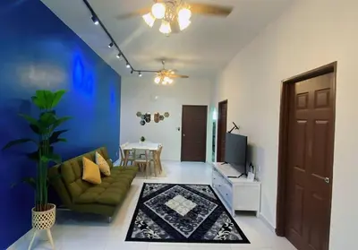 a living room with a green couch and a tv at R&R Manjung Guest House at Pangsapuri Samudera in Seri Manjung