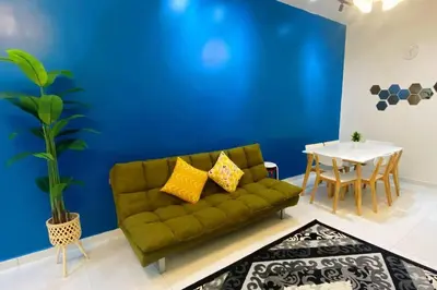 a living room with a green couch and a table at R&R Manjung Guest House at Pangsapuri Samudera in Seri Manjung