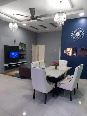 a dining room with a table and chairs and a tv at Puteri Homestay Sg Petani in Sungai Petani