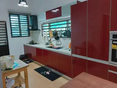 a kitchen with red cabinets and a counter top at Puteri Homestay Sg Petani in Sungai Petani
