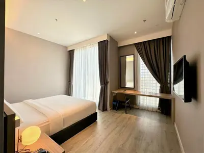 a hotel room with a large bed and a desk at Corner Club Penang in George Town