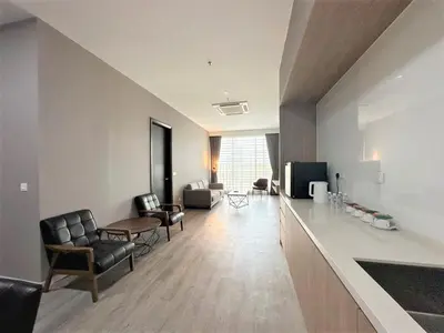a living room with leather chairs and a television at Corner Club Penang in George Town